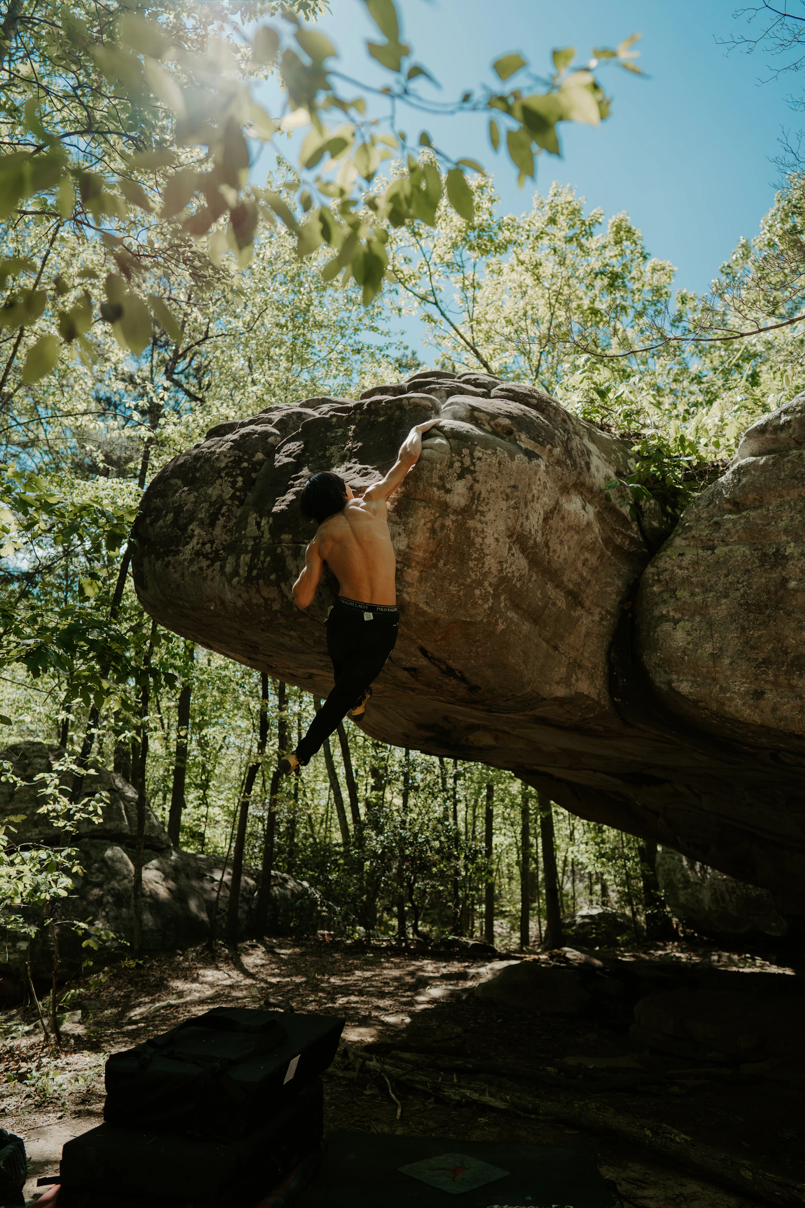 A climber on a natural rock in a forest